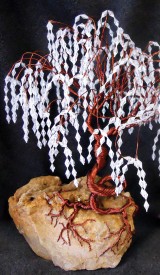 Learning to make Ming trees is just one of the many art forms available to students through the SunBird Lapidary Club. These examples, by teacher Muriel Davis, are on display along with other club member projects in the case by the Lapidary Shop on the upper level of the Clubhouse.