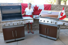 Carolyn Tomlinson proudly displays the two new barbecue grills recently gifted from the Canadian Club to the HOA.
