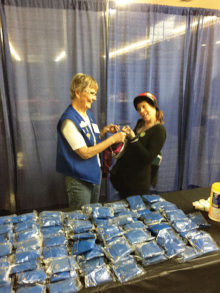 SunBird Lions President Julie Napton shares a laugh with a patient while issuing reading glasses
