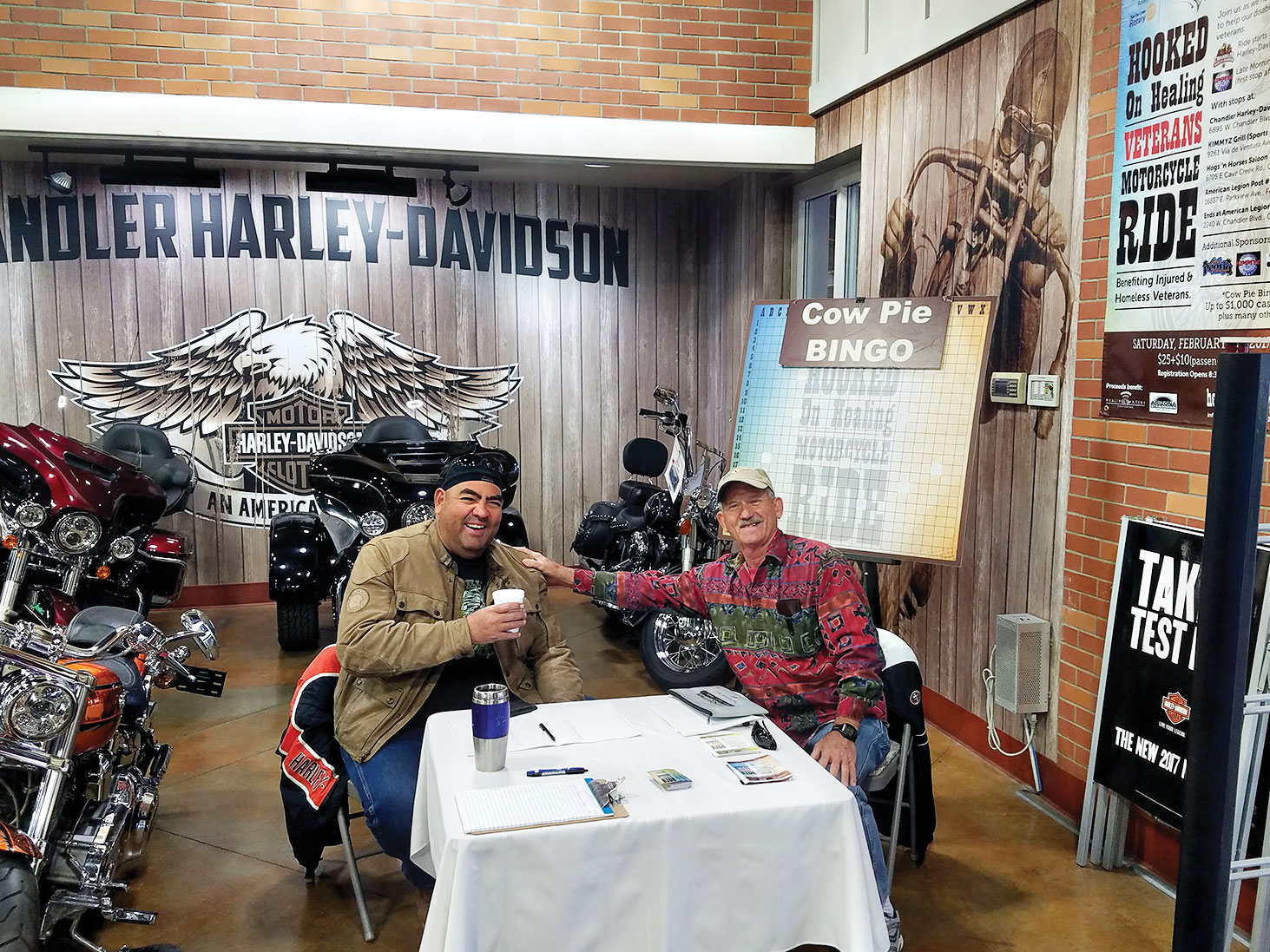 San Tan Crown Rotarians Terry Lubsen and James Kame hard at work selling Cow Pie Bingo tickets at Chandler Harley-Davidson January 7, 2017.