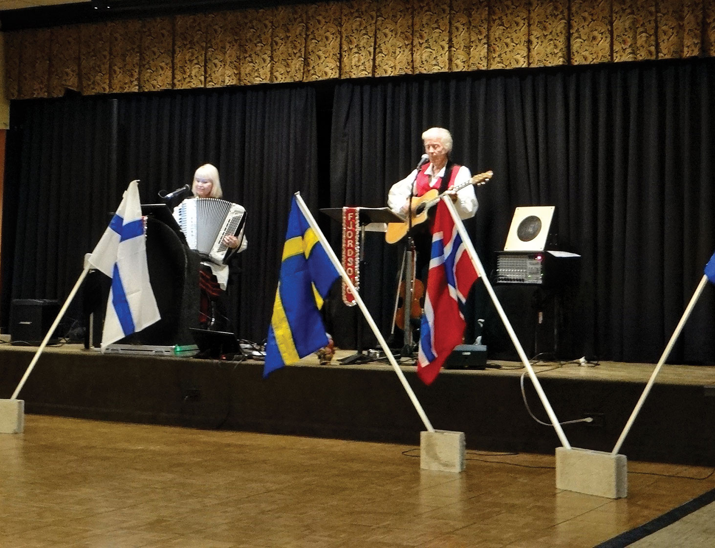 Celebrating our Scandinavian heritage with the five countries flags and national anthems on March 17 are Sylvia Jorgensen and Carl Nyberg.