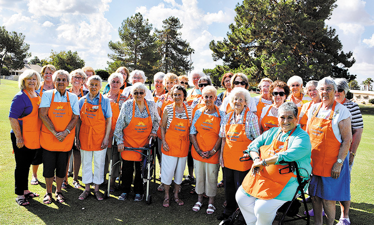 The Sun Lakes Women's Association members getting ready for the Fall Bazaar in their "striking" orange aprons