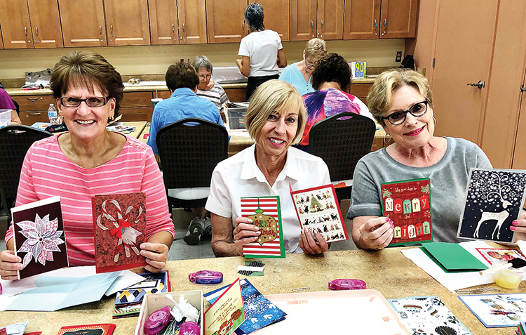 Pat Krafcik, Virginia Diers, and Kathy Skrei show some of the holiday cards available from the Crystal Card project.