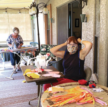 Jacque VanDamme and Pat Seabert work on masks on Jacque's patio. Kathy Bartlett and Kathy Husback also joined in the effort.