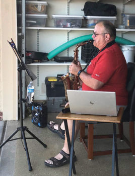 Pat Kelly playing his saxophone from his garage during Five O'Clock Friendly Hour